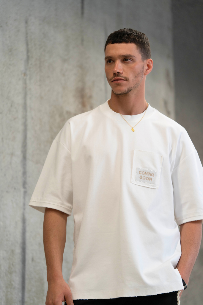 חולצת ציצית לבנה דגם STONES OF HOPE על דוגמן בצילומי סטודיו - תקריב פרונט רקע בטון