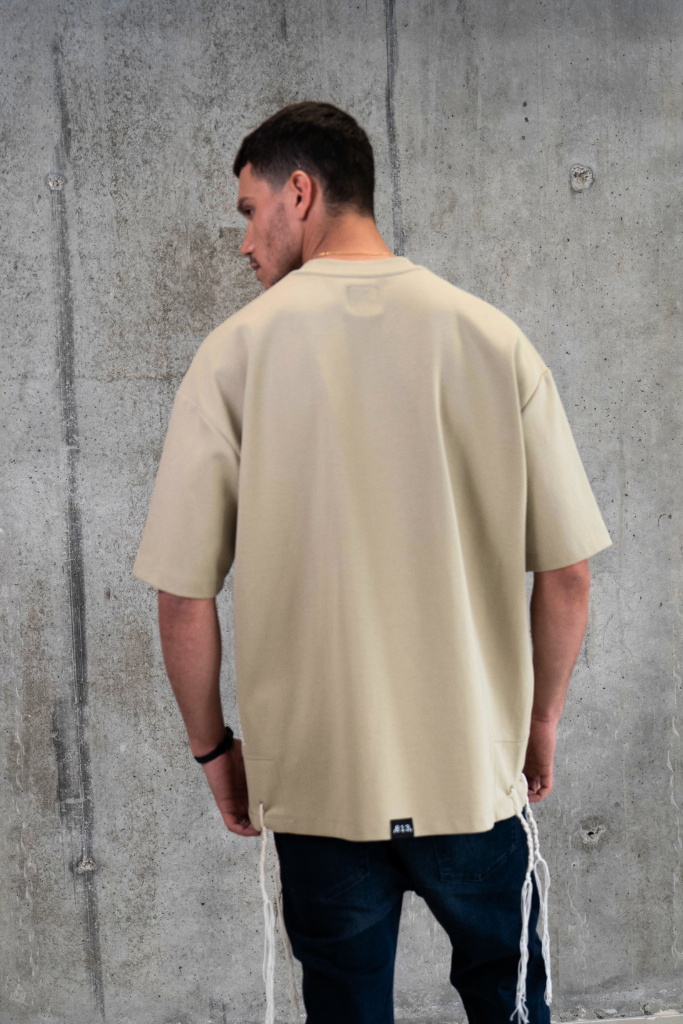 חולצת ציצית כאמל דגם WINGS OF VISION על דוגמן בצילומי סטודיו - גב רקע בטון